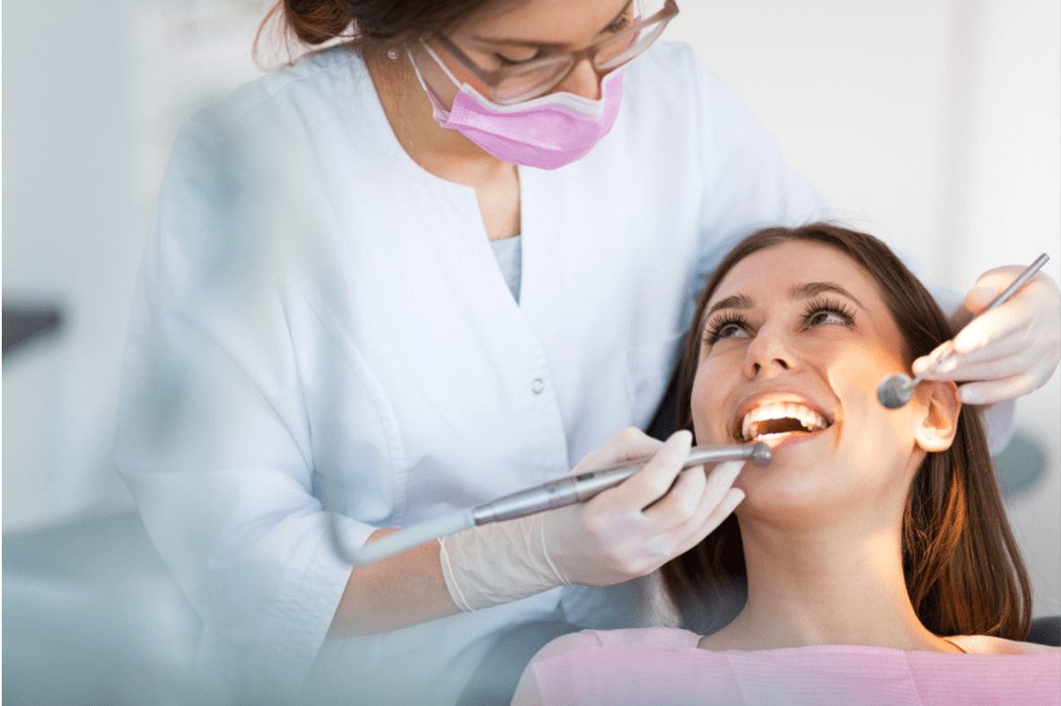 a woman having her teeth inspected by a dentist (because of a suspected chipped tooth)