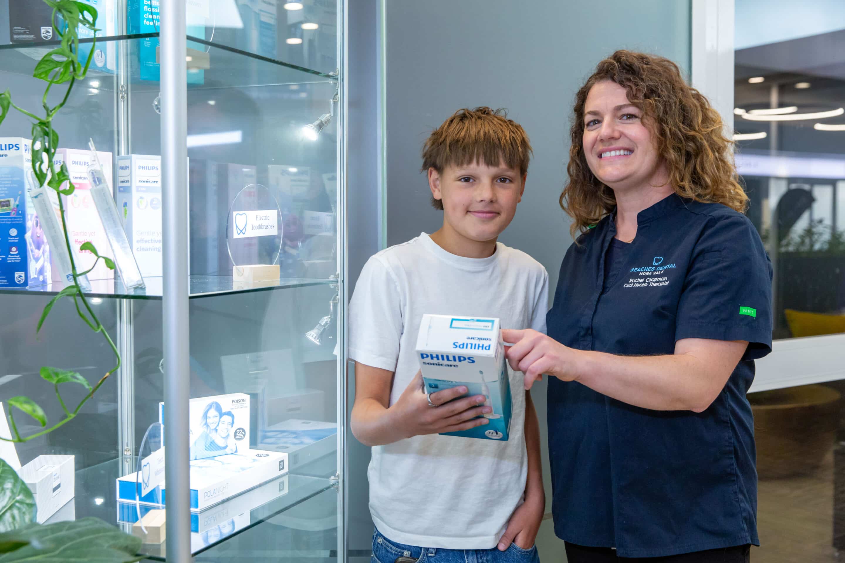 Dentist smiling with patient holding toothbrush