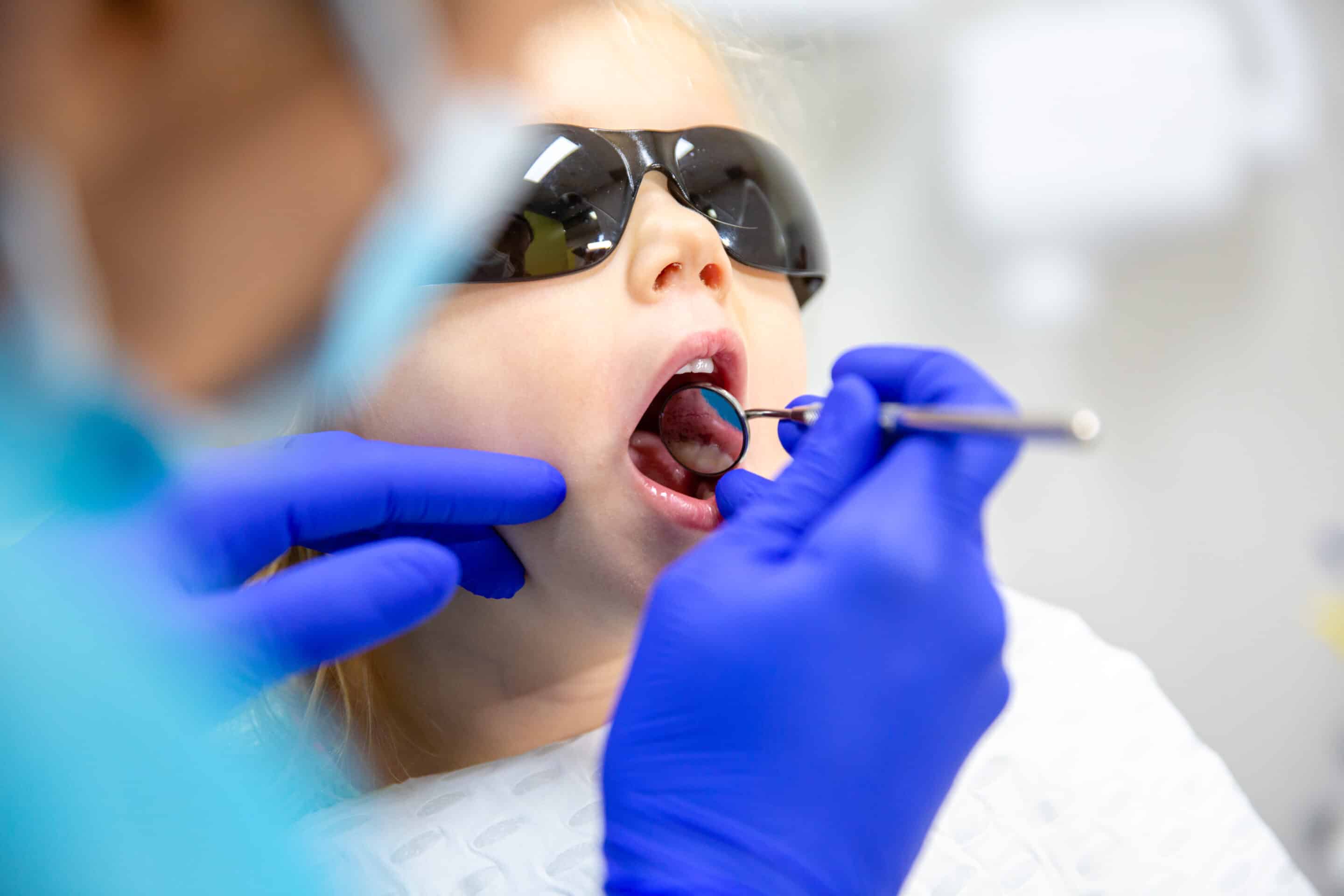 Dentist examining child's mouth for cavities