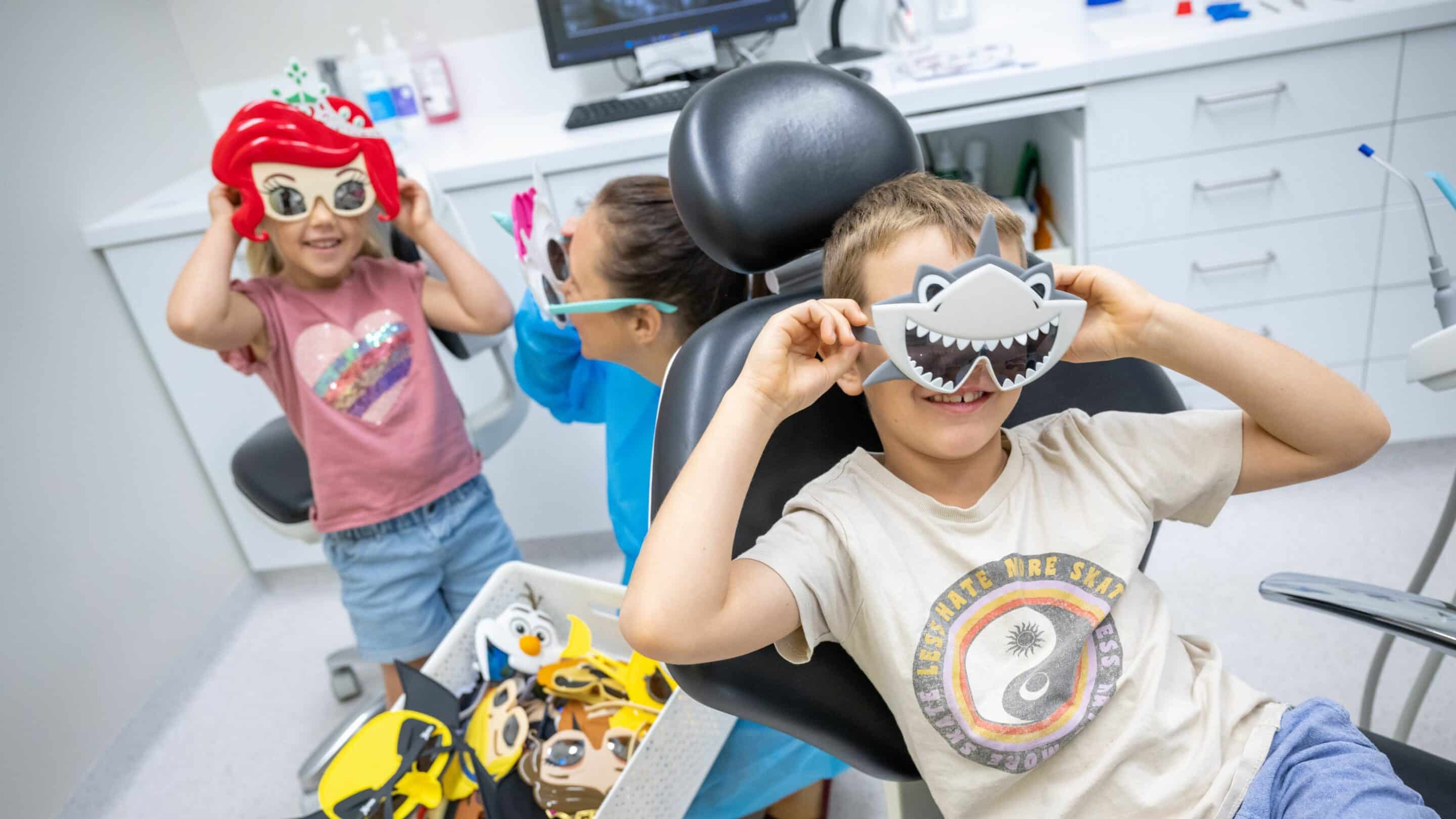 Dentist having fun with children in dental office.