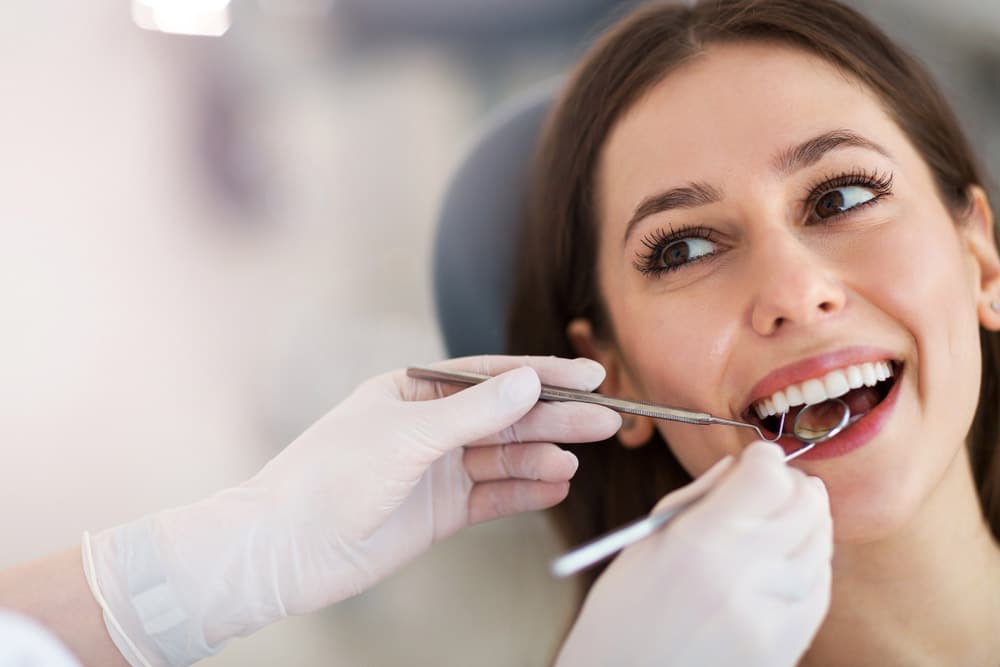 a woman seated on a dental chair for a root canal therapy