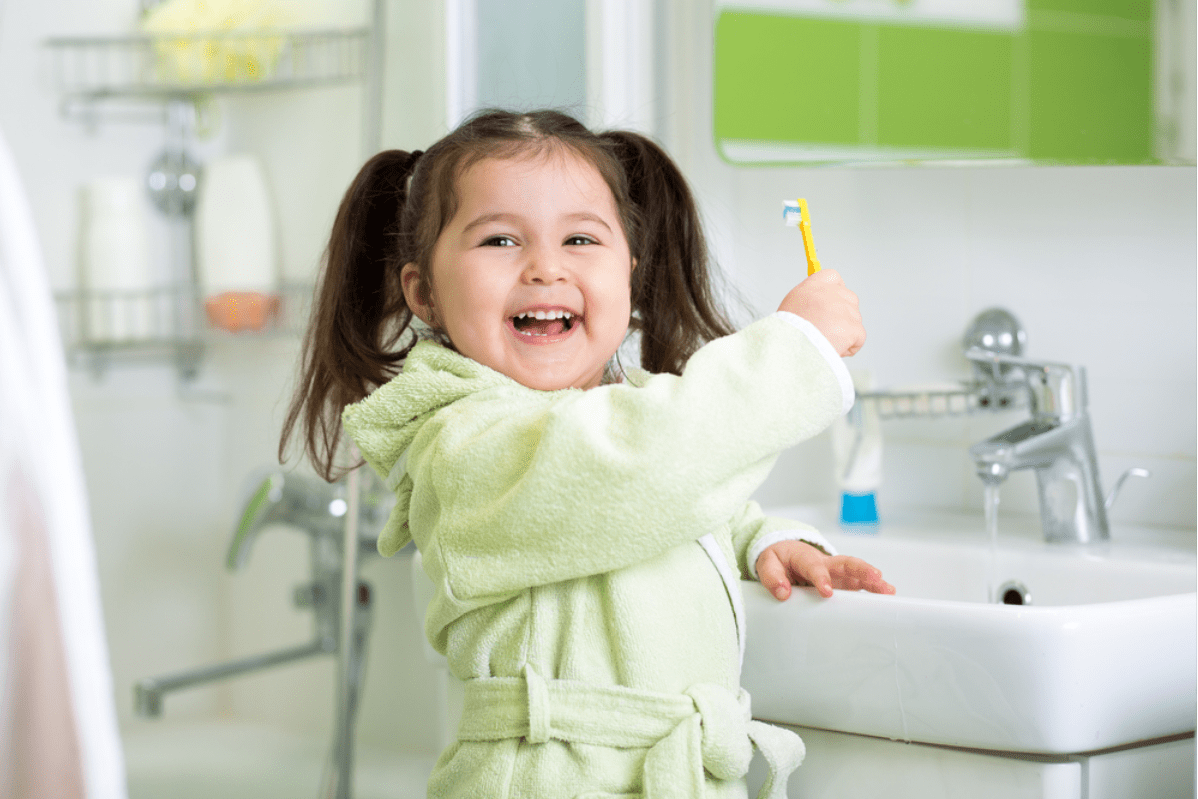 a young girl practicing good dental habits by brushing her teeth