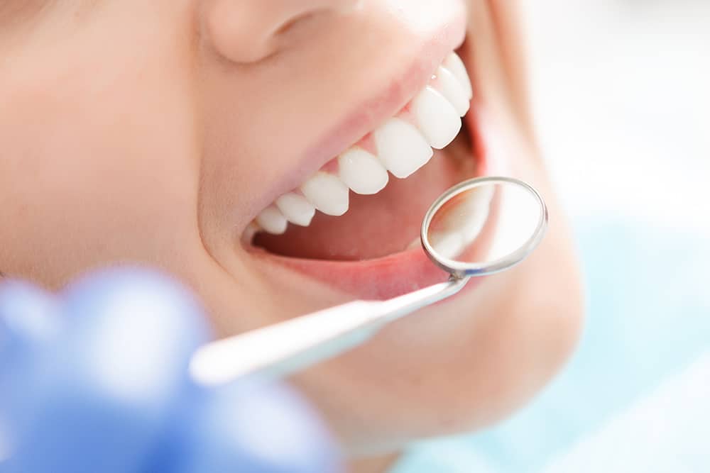 a mouth mirror being used to check for oral health