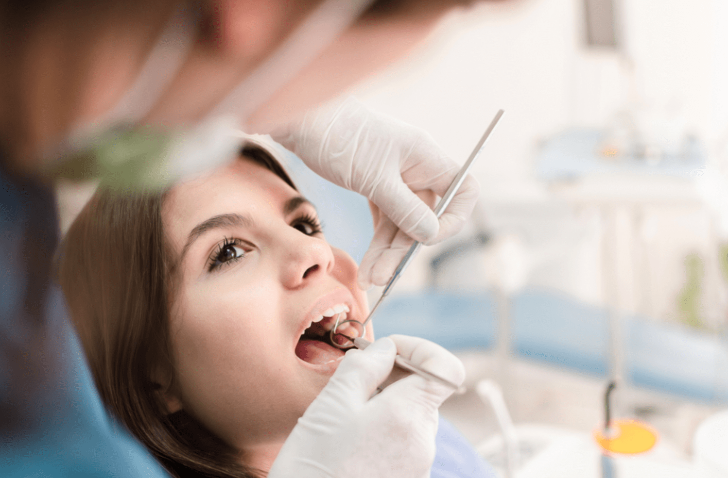 a woman having her teeth inspected by a dentist