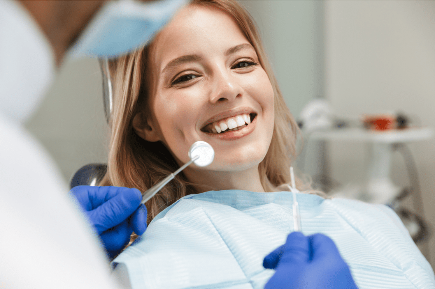 a young woman seated on a dental chair for her routine dental checkup and clean