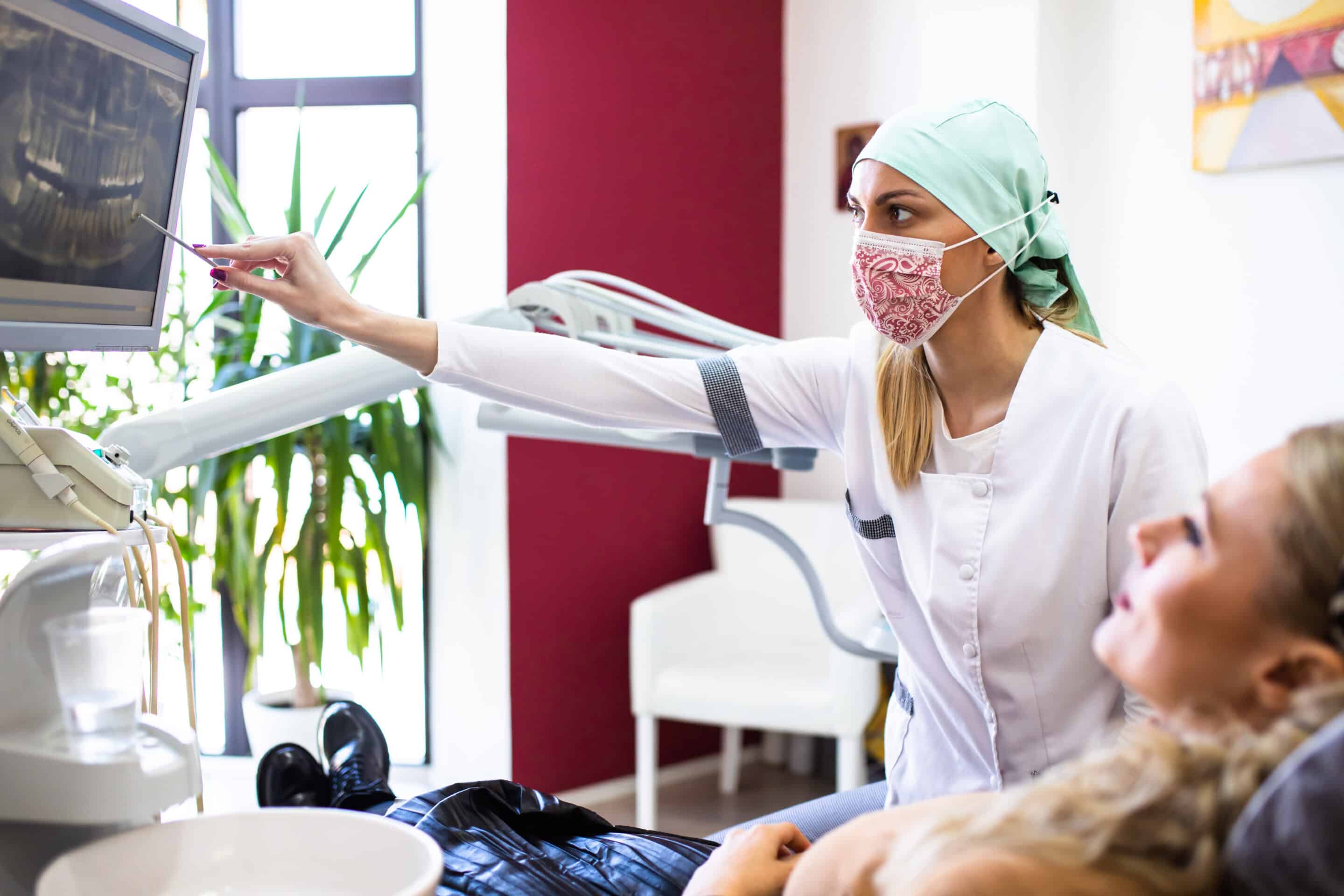 A female dentist showing a patient her digital dental X-ray