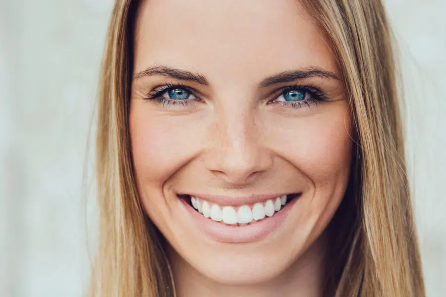 a woman smiling because of her beautiful veneers