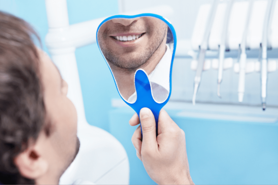 a man seeing his symmetrical smile on a mirror